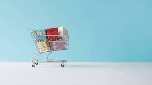 Mini shopping cart filled with colorful gift boxes supporting the difference between design simplicity and ecommerce depth