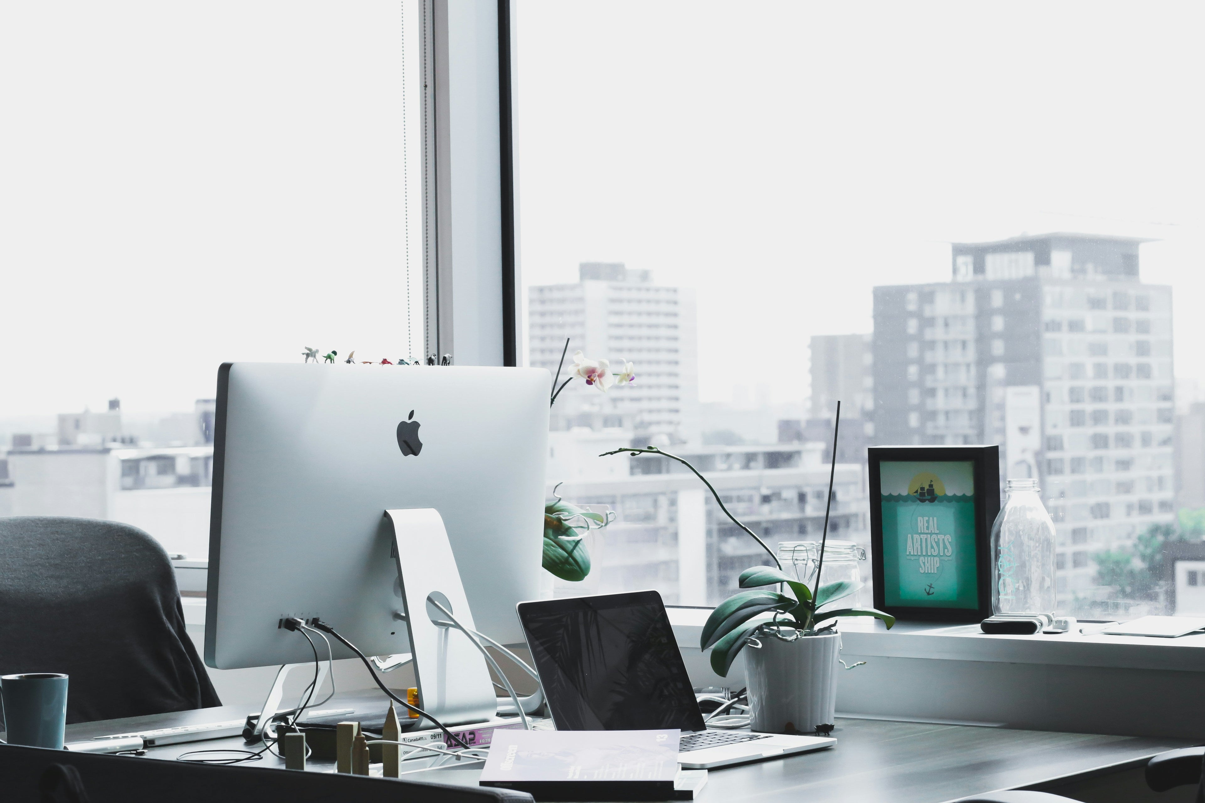 Modern workstation with city view supporting what changes after a Shopify store passes one million in revenue