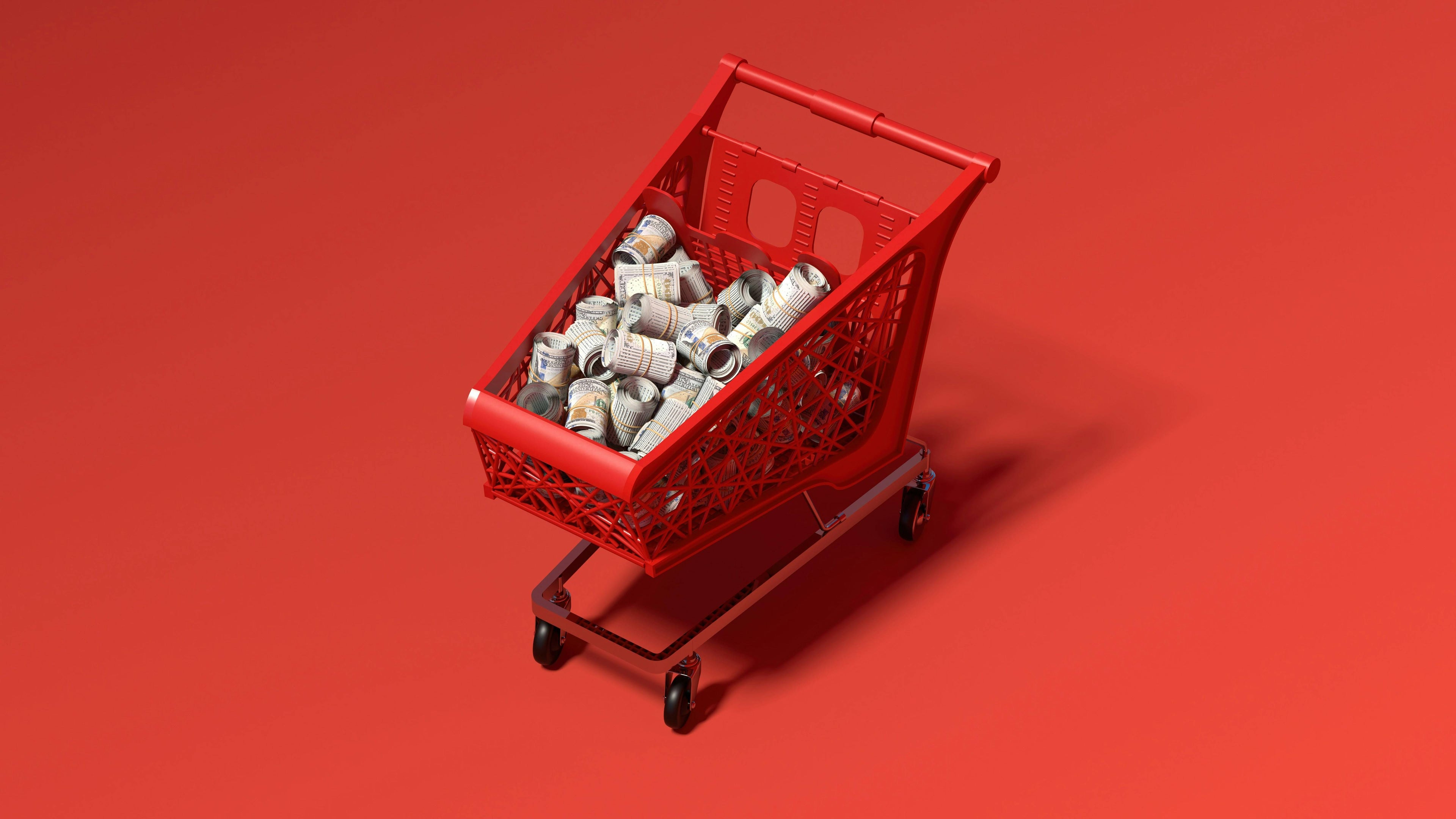 Red shopping cart filled with cash supporting the daily operational cost and value differences between Shopify plans